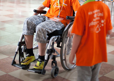 ein KinderuniWien-Studierender testet das Rollstuhlfahren in einem Workshop