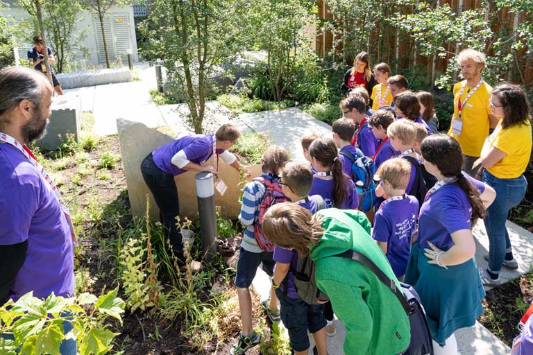 Children in a Vienna Children's University workshop examine plants in the garden