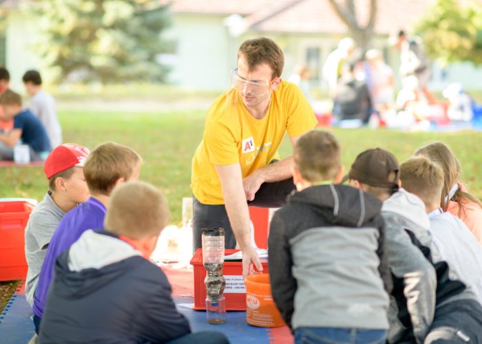 Kindergruppe und Mitarbeiter beim Experimentieren