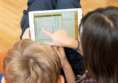 a girl and a boy solve a puzzle together on the tablet at kinderuni.online