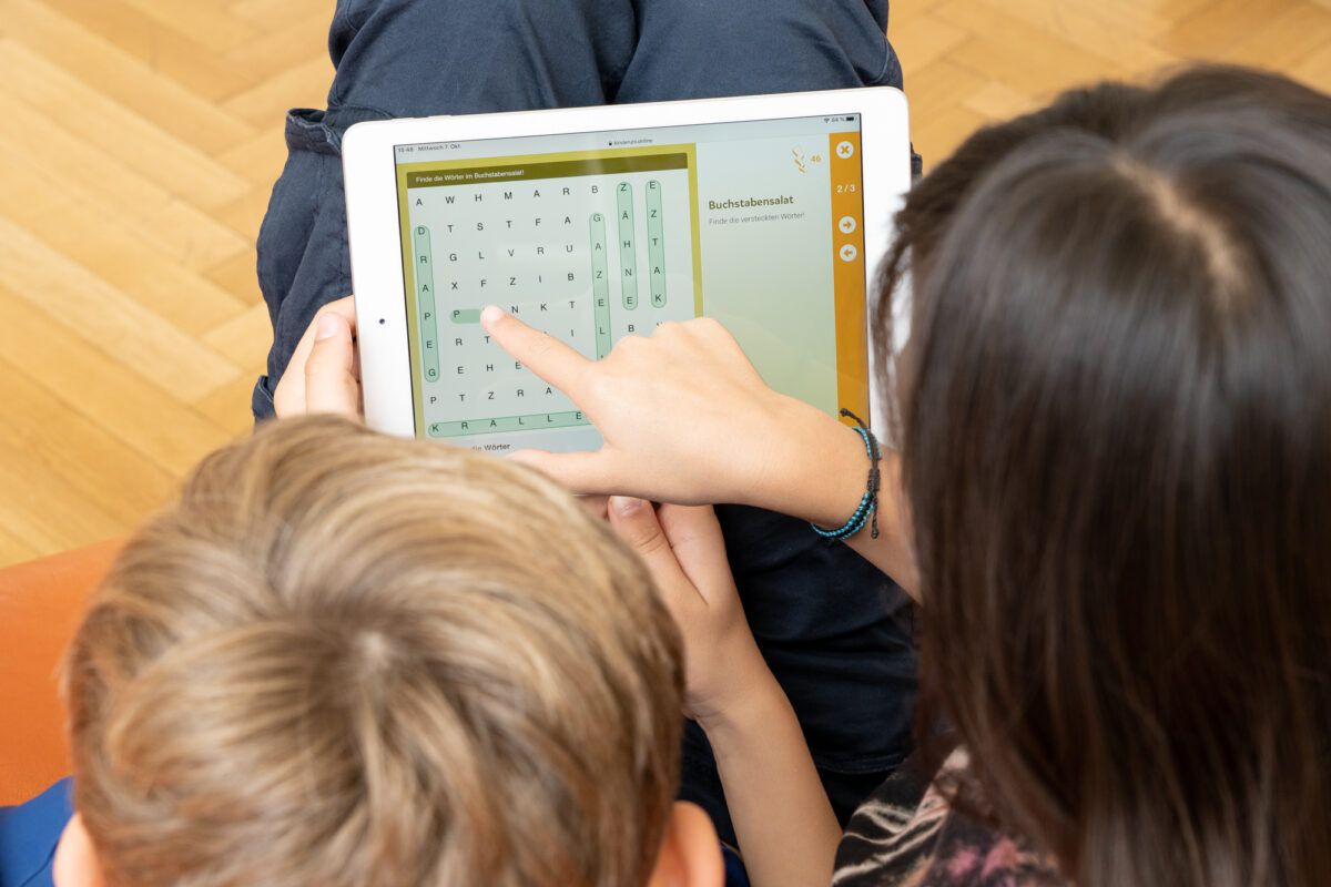 a girl and a boy solve a puzzle together on the tablet at kinderuni.online