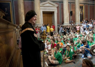 Vienna Children's University Graduation Ceremony in the Main Ceremonial Hall: the sceptre-bearer rejoices, in the background many children sit on the floor