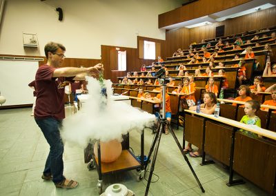 ein Lehrender experimentiert mit flüssigem Stickstoff im Hörsaal