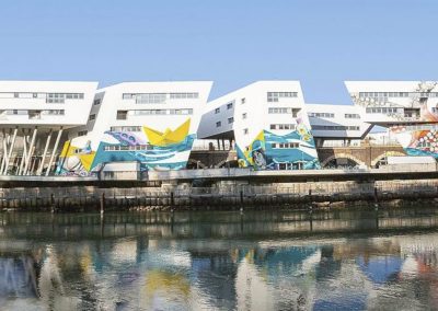 Exterior view of DOCK: colorful building facade and Danube Canal