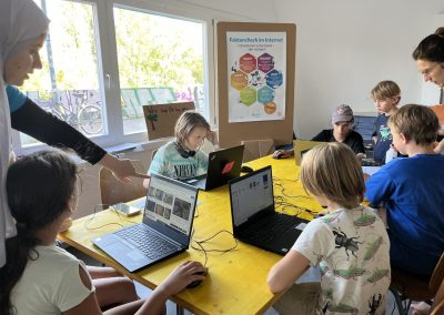 Children with laptops at the DOCK, poster fact check on the Internet