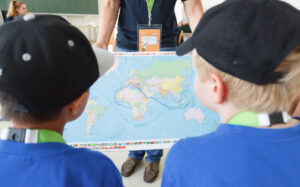 KinderuniWien-Studierende mit Weltkarte
