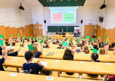 VCU students in a lecture answer a question by holding up colored cards