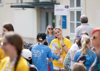 beim Treffpunkt wird ein Lehrveranstaltungsschild von einem Teammitglied hochgehalten