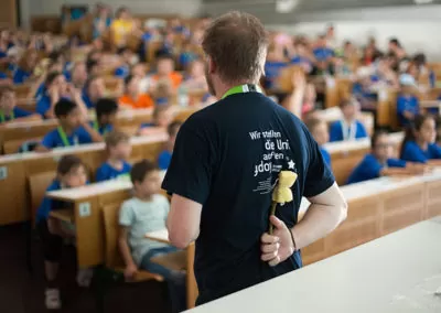 ein Lehrender versteckt Schwamm hinter seinem Rücken