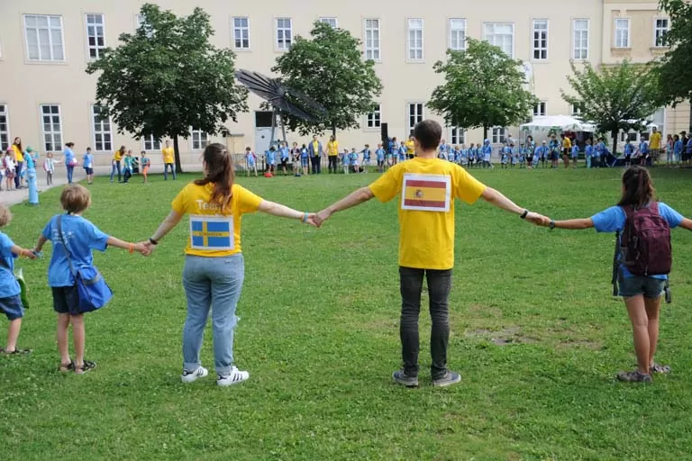 Kinder und Team geben sich die Hände und bilden einen Kreis