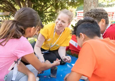 Kinder und Teammitglied beim Experimentieren an der Kinderuni on Tour